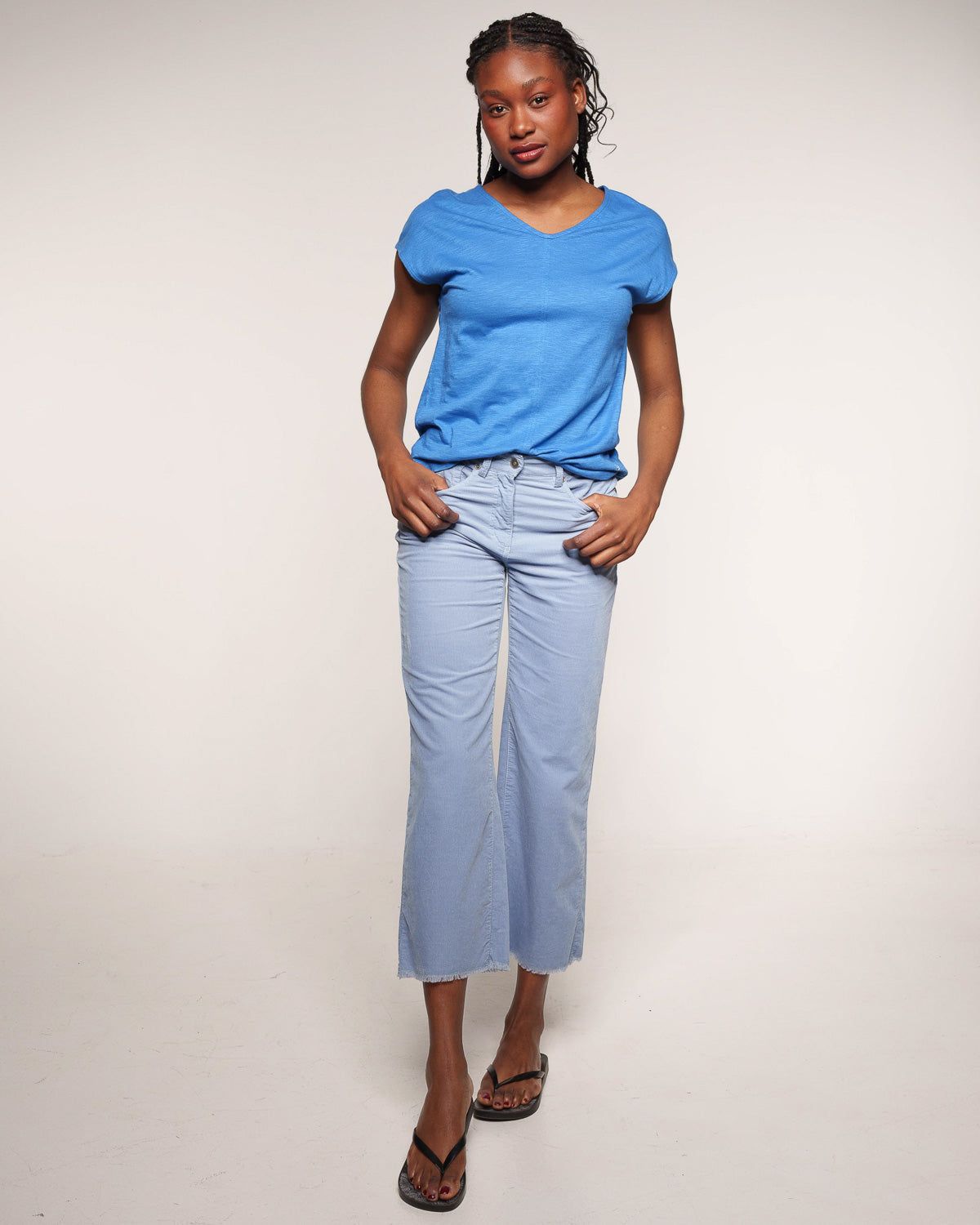Frau mit hellblauer Cordhose und blauem T-Shirt