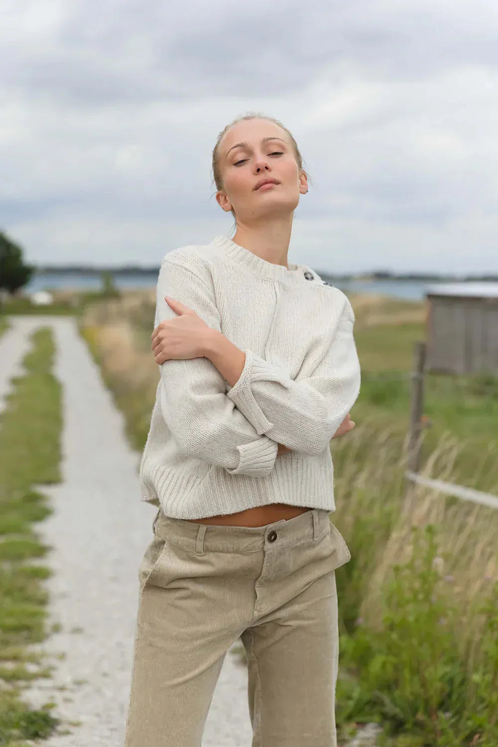 Wollpullover - 100% Wolle mit Knopfdetails, locker geschnitten, ideal für Herbstspaziergänge, kombiniert mit Cordhose in Naturtönen.