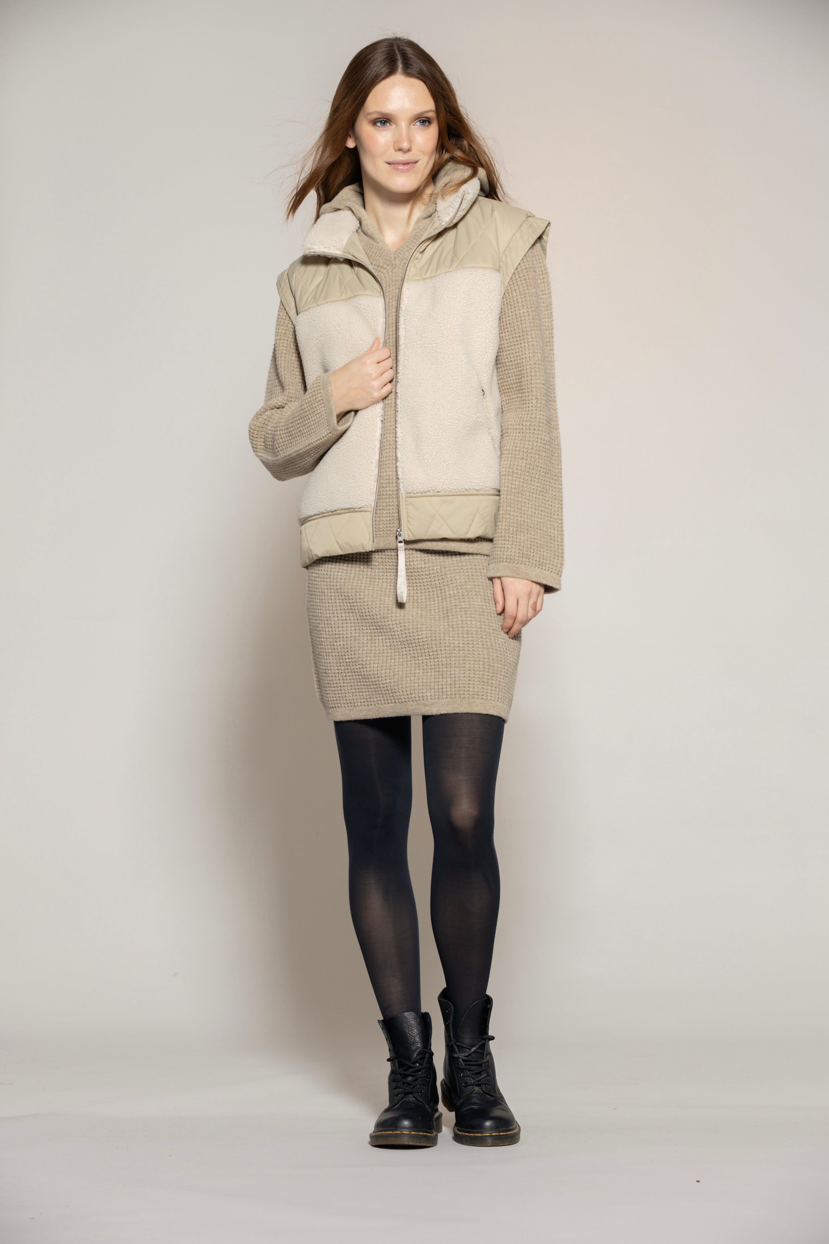 Modischer Merinowolle Hoodie Damen in Beige, kombiniert mit Rock und Weste, ideal für Herbst-Layering, atmungsaktiv und stilvoll.