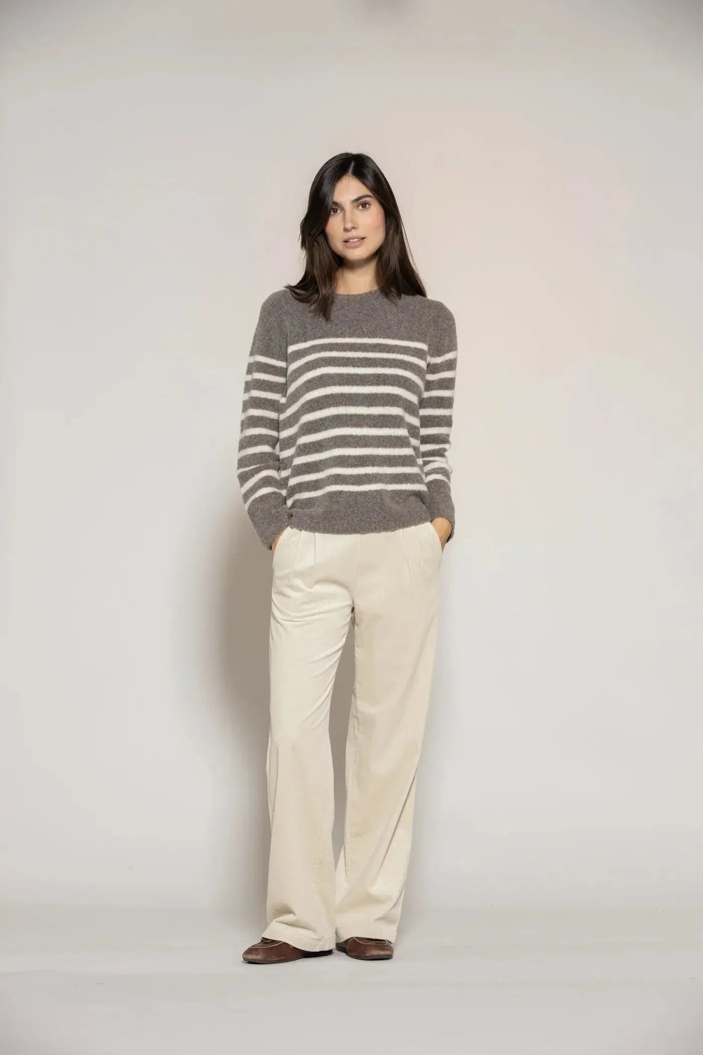 Bouclé Pullover - Gestreifter Damen Pullover aus weicher Wolle in Braun mit weißen Streifen, kombiniert mit heller Stoffhose für modernen Look.