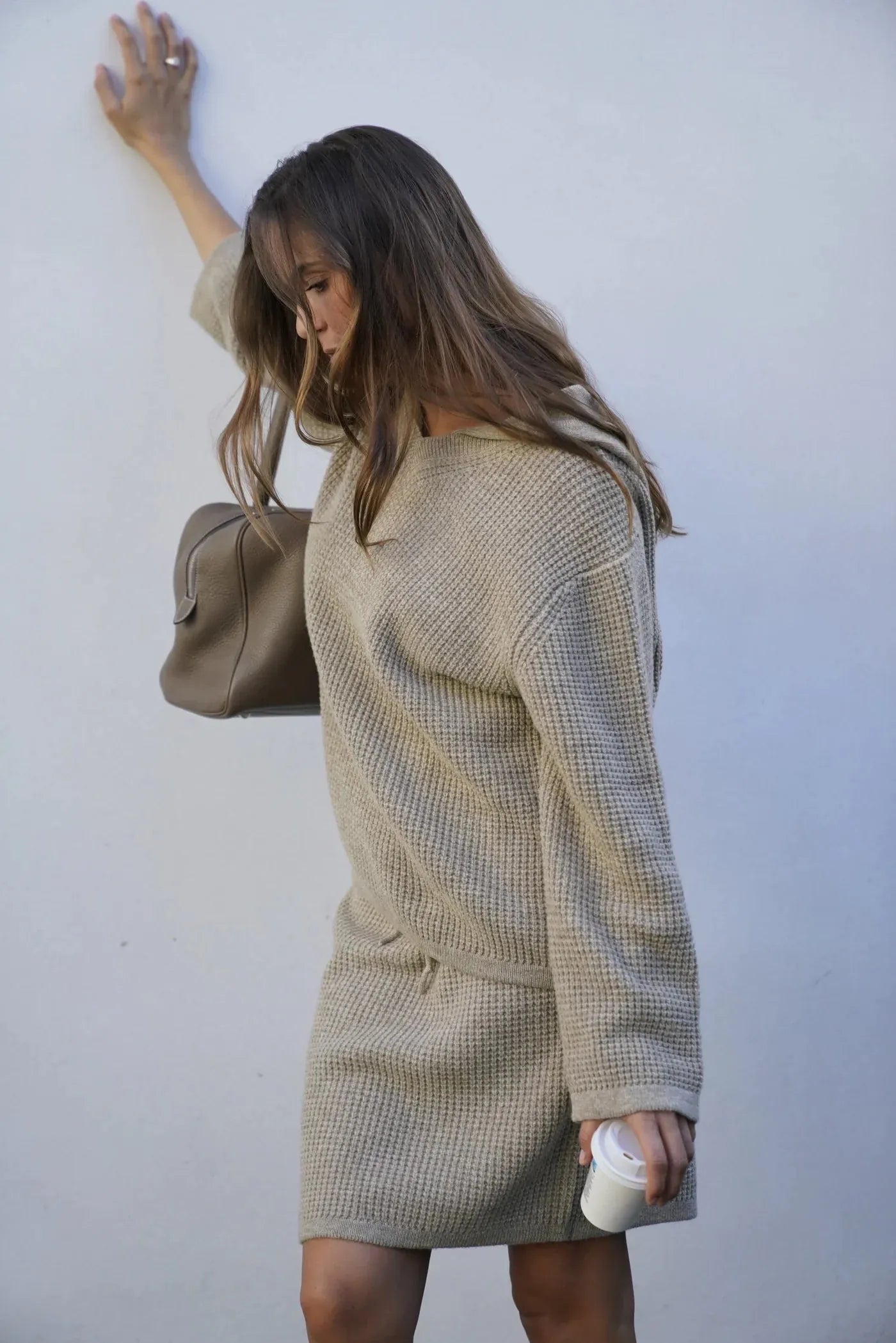 Bequemer Damen Hoodie aus Merinowolle in Beige, nachhaltig produziert, kombiniert mit Rock, ideal für moderne Casual-Looks.
