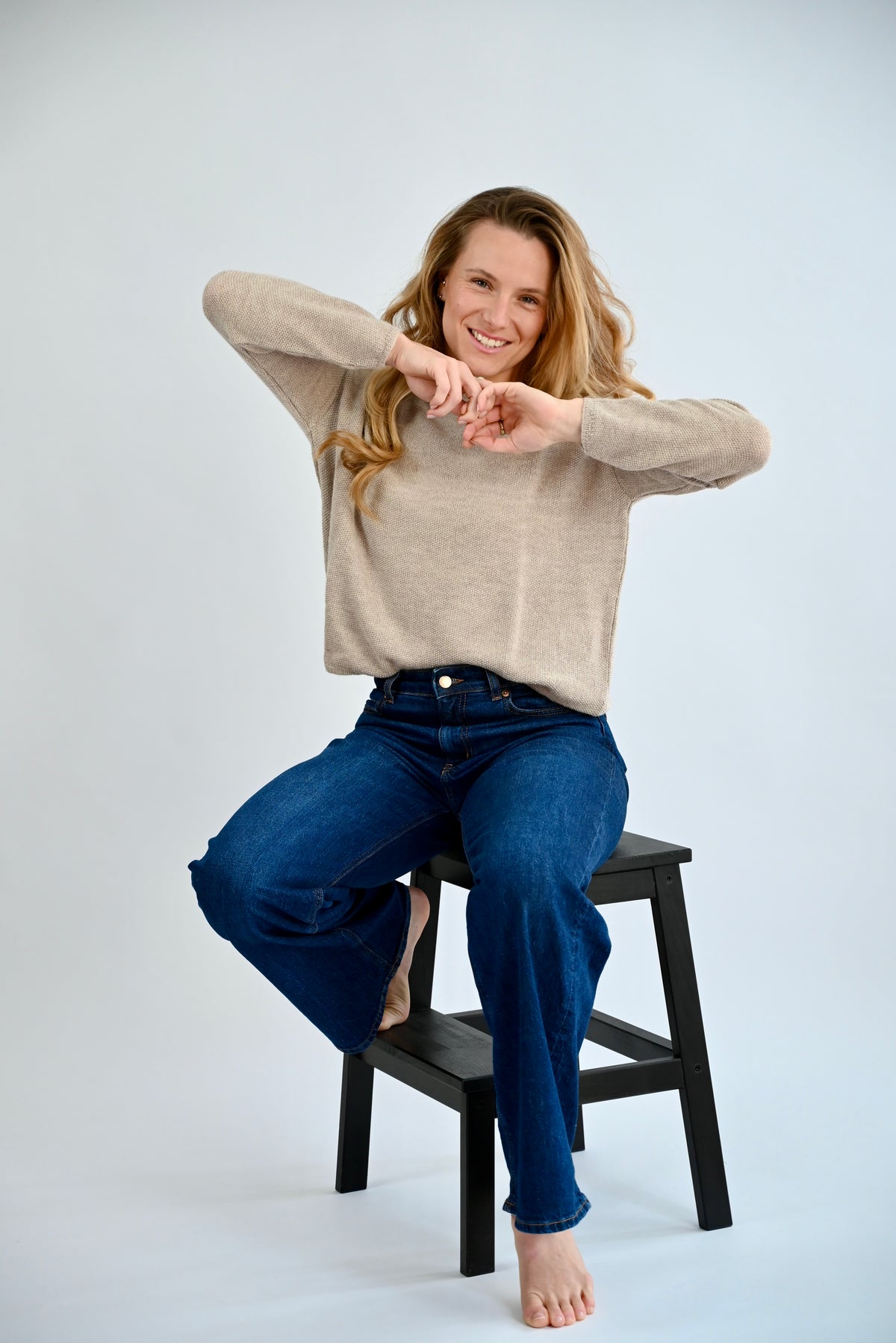 DANA Raglan Sweater in Light Grey, sitzende Ansicht am Model, Raglanärmel und Bewegungsfreiheit sichtbar