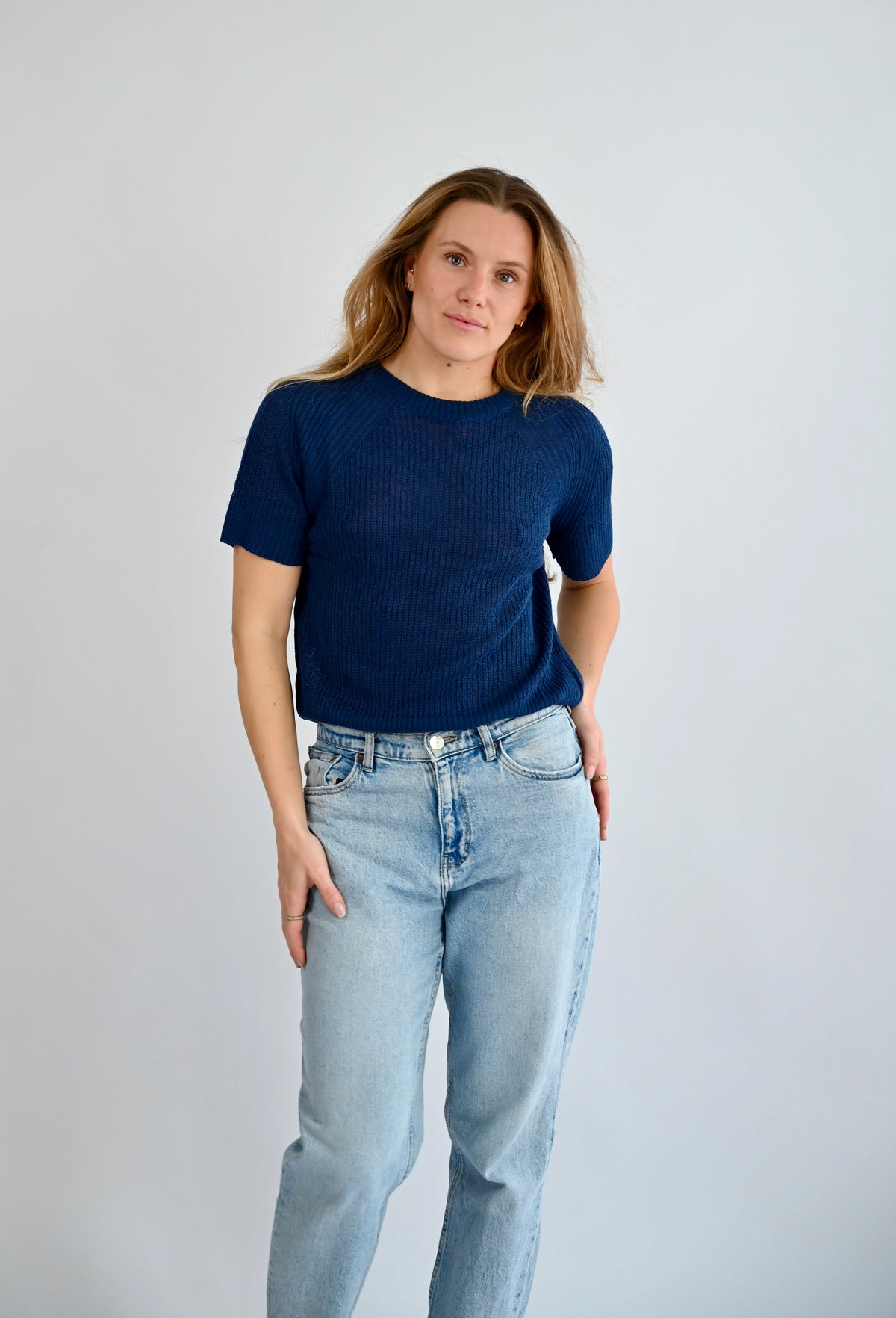 ELODIE Ribb Sweater blau, Frontansicht am Model mit kurzem Arm und Rundhalsausschnitt, kombiniert mit heller Jeans #farbe_blau