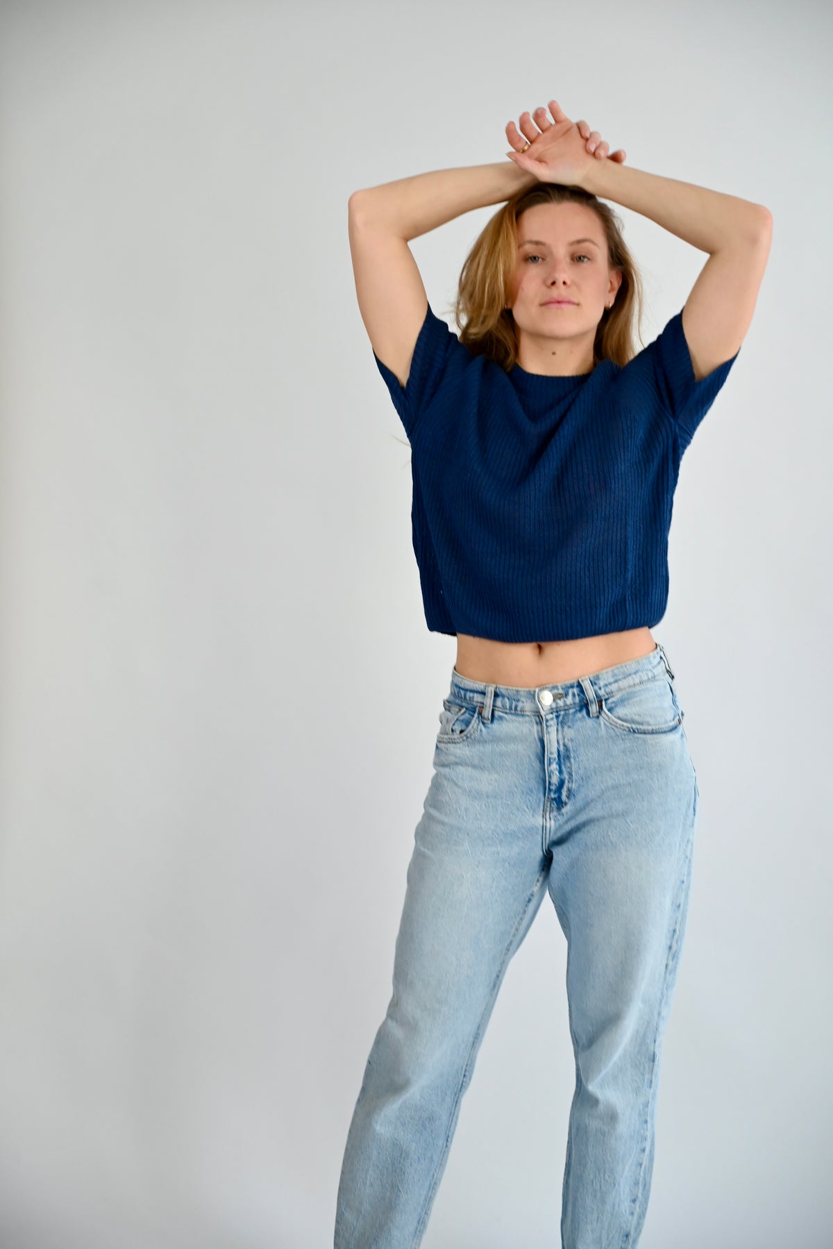 ELODIE Ribb Sweater in blau, Ansicht von vorne am Model mit kurzem Arm und Rundhalsausschnitt, kombiniert mit heller Jeans #farbe_blau