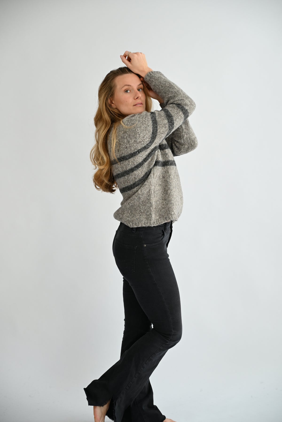 GIVRE Crew Neck Sweater in Grau/Anthrazit, Seitenenansicht am Model mit erhobenen Armen, Passform und Länge sichtbar