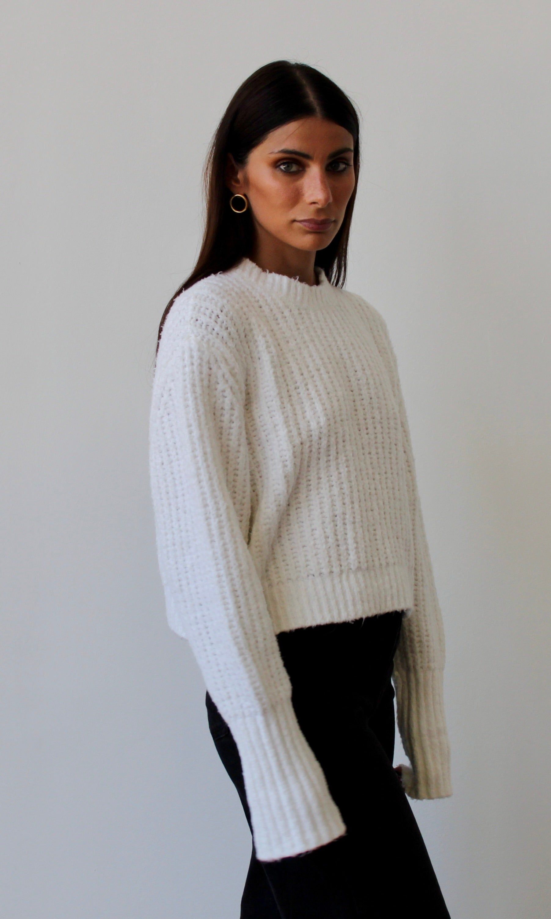 Frau mit weißem, grob gestricktem Baumwollpullover