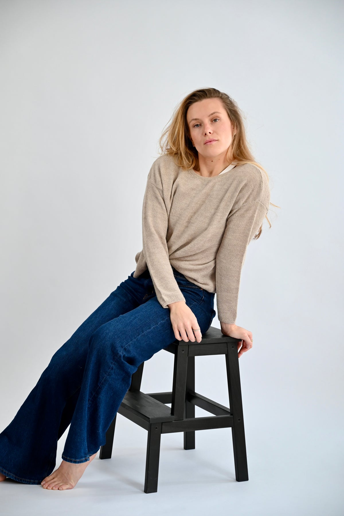DANA Raglan Sweater in Light Grey, lässige sitzende Pose am Model, Reisstich und weite Ärmelstruktur sichtbar