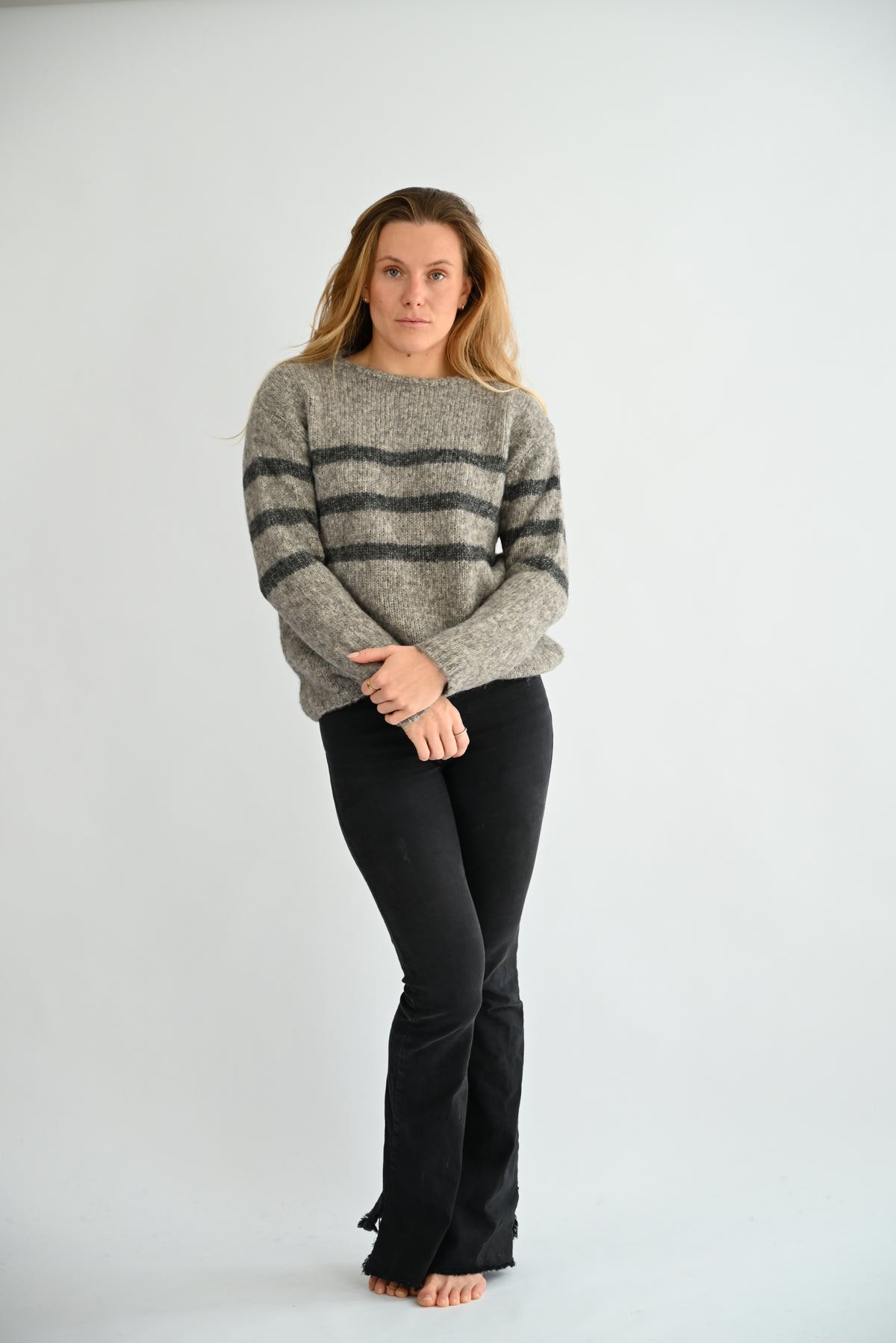 GIVRE Crew Neck Sweater in Grau/Anthrazit, Ganzkörper-Frontansicht am Model, lockere Passform mit anthraziten Streifen, kombiniert mit schwarzer Hose