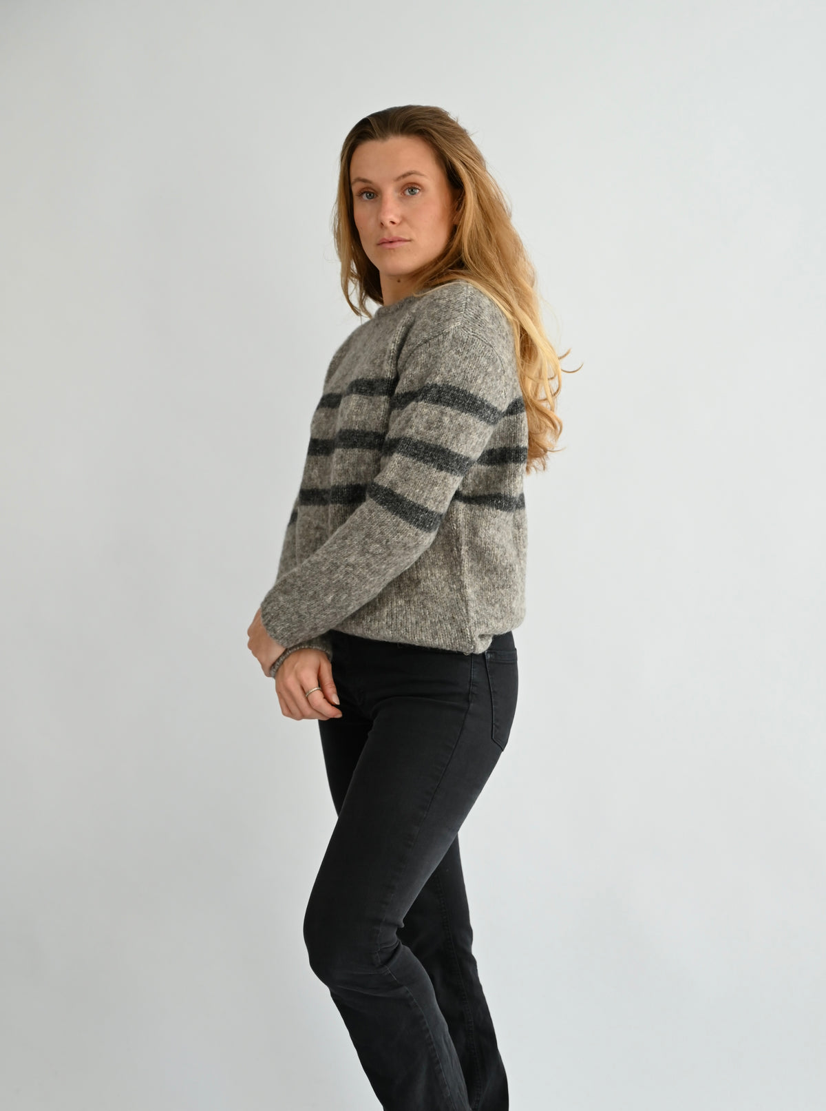 GIVRE Crew Neck Sweater in Grau/Anthrazit, Seitenansicht am Model, überschnittene Schultern und Streifenmuster sichtbar