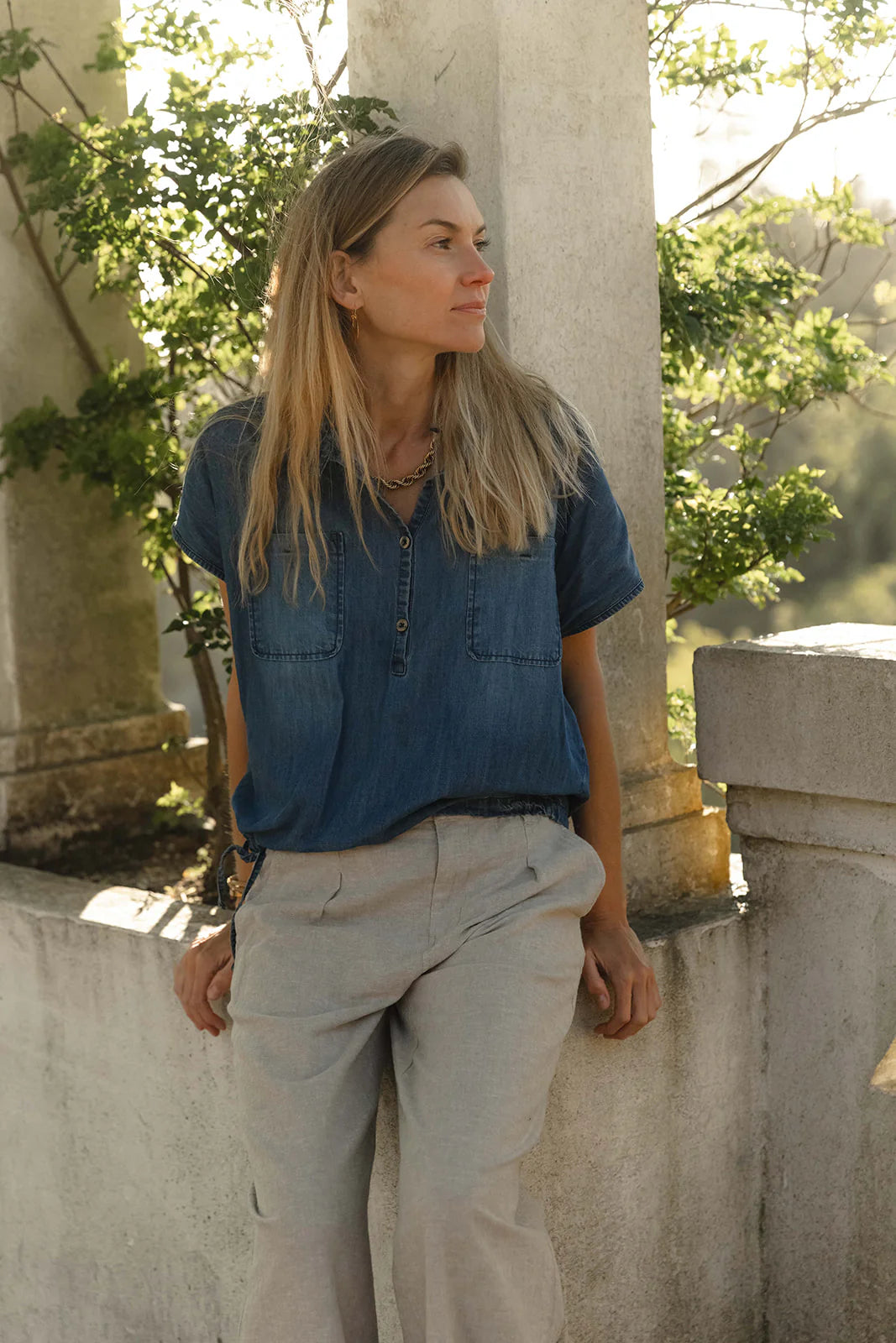 Frau trägt DUX Denim Shirt in Denim Blue kombiniert mit heller Leinenhose – myloook