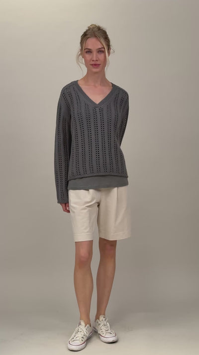 Frau trägt grauen Strickpullover mit V-Ausschnitt und Lochmuster Video