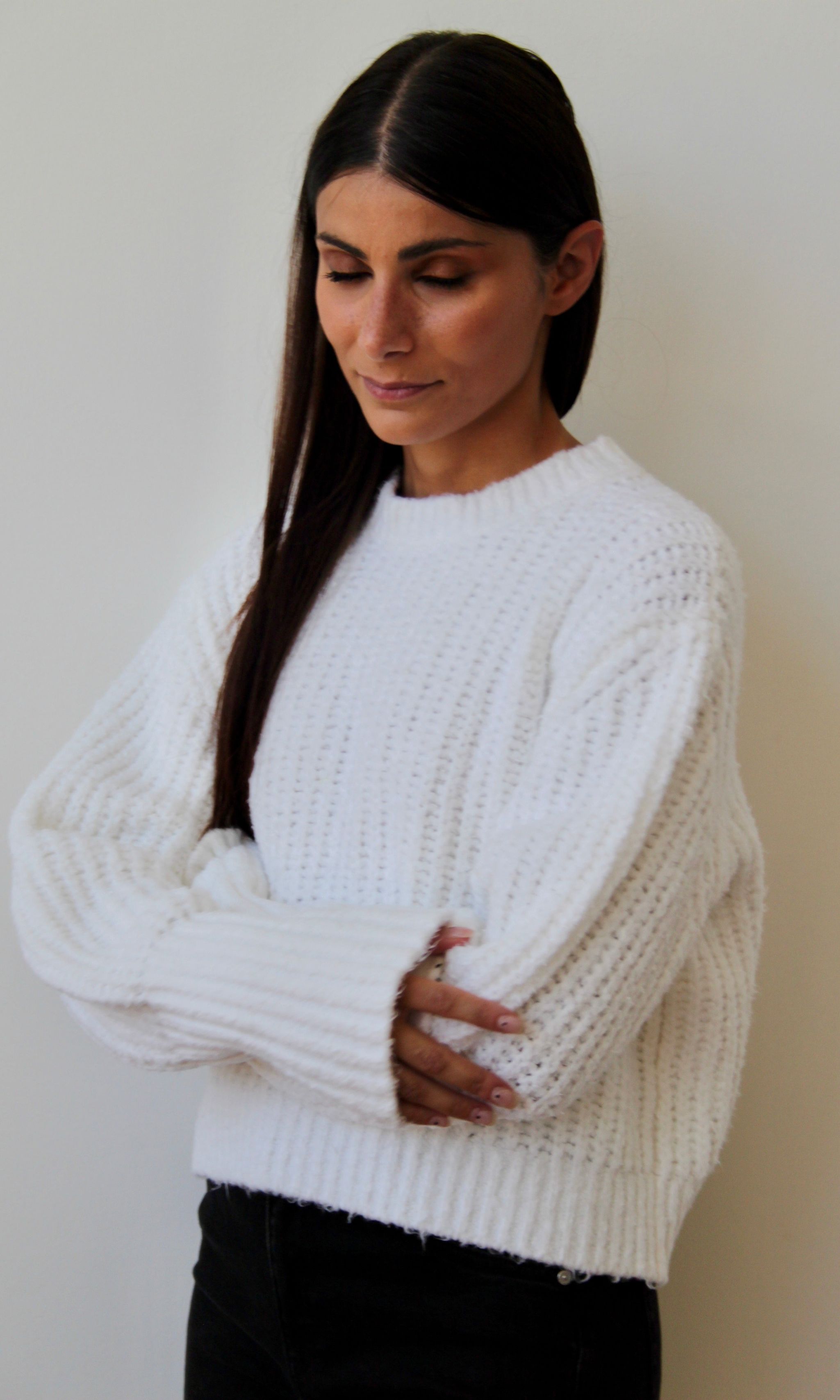 Frau mit weißem, grob gestricktem Baumwollpullover